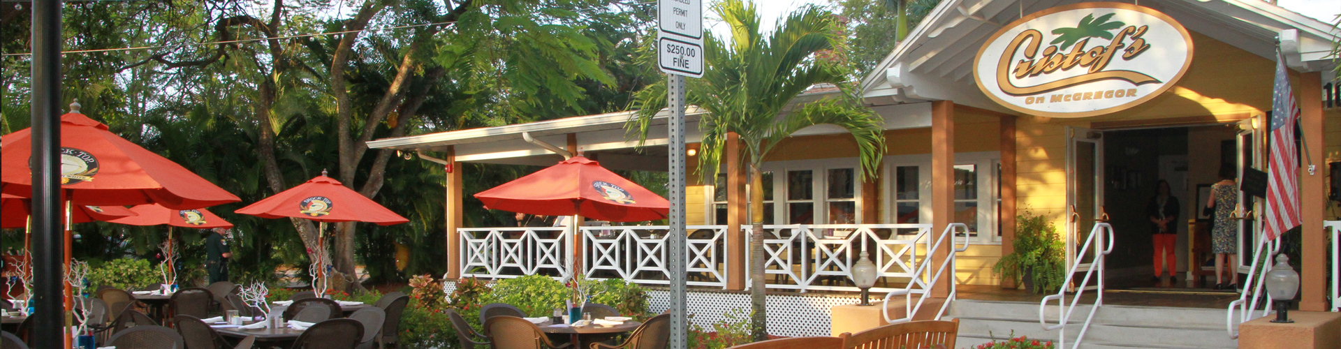 Cristof’s on McGregor entrance and outdoor patio with red umbrellas and surrounding trees