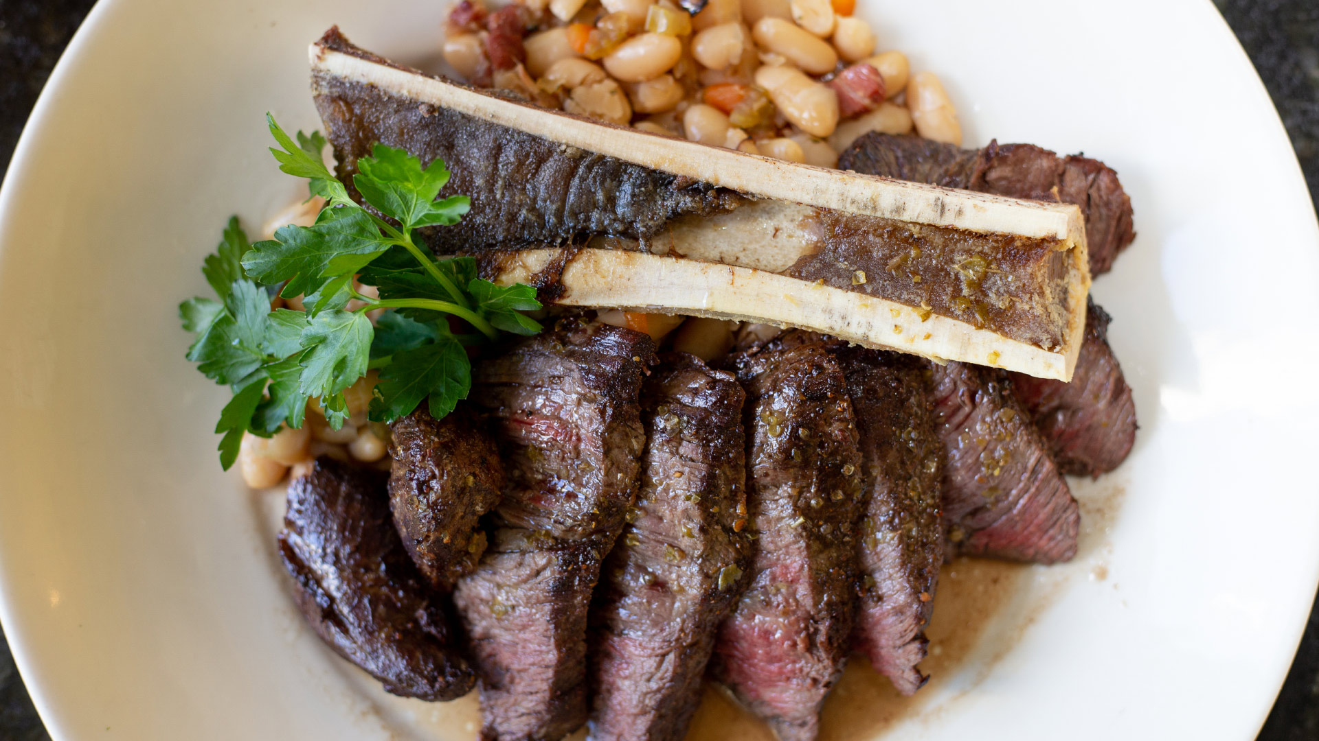 A grilled bone-in steak with vegetables at Cristof’s